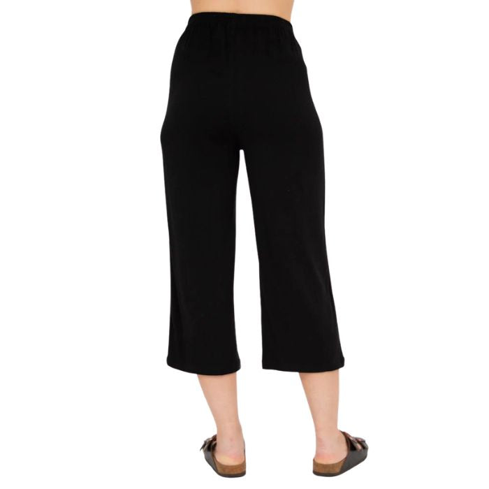female model wearing black bella capri pants back view on white background