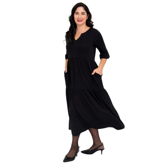 female model wearing black bernadette dress side view on white background