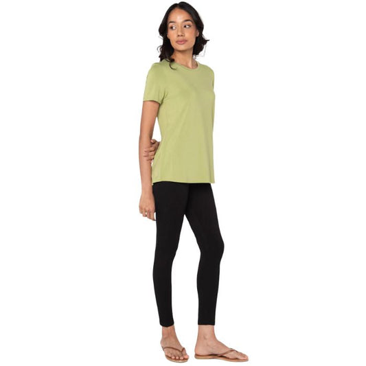 female model wearing cirton green gracie crew neck t-shirt and black suri leggings front view on white background