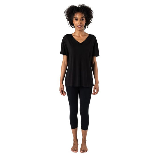 female model wearing black harper tee and black suri capri leggings front view on white background