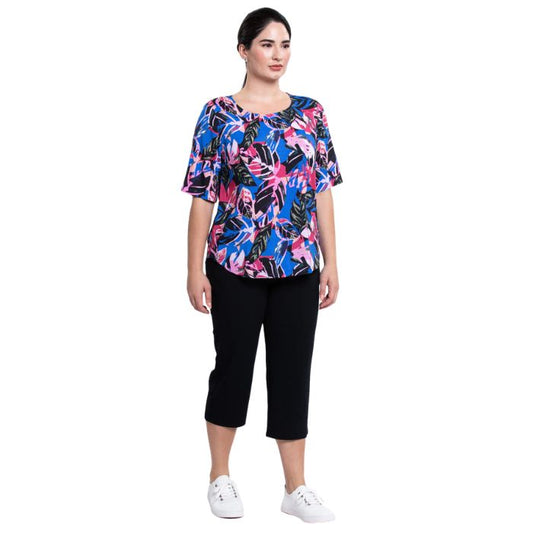female model wearing pink bonita print liza top and black nadine cropped pants front view on white background
