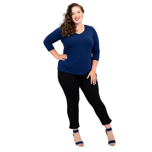 female model wearing mia indigo blue three quarter sleeve top and nadine black cropped pants front view on white background