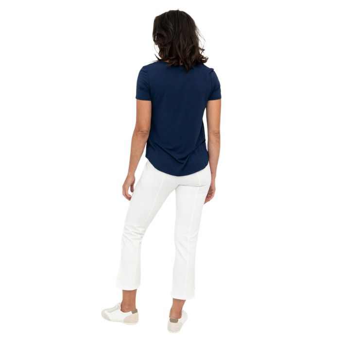 female model wearing white nadine cropped pants and indigo blue tessa tee back view on white background