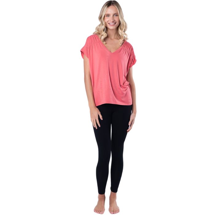 female model wearing coral pink alicia v-neck top and black suri leggings front view on white background