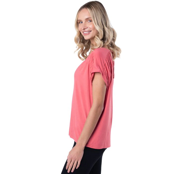 top of female model wearing coral pink alicia v-neck top side view on white background