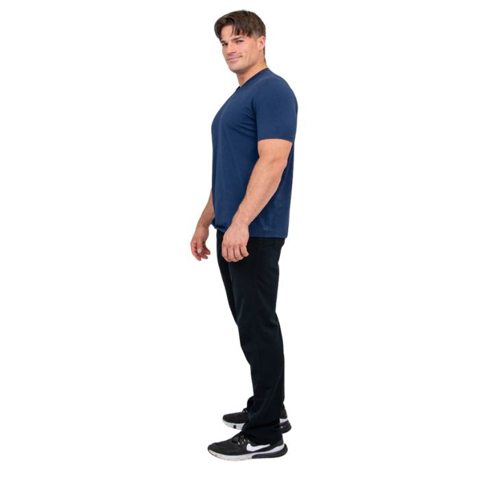 male model wearing indigo blue adam short sleeve shirt and black pants side view on white background