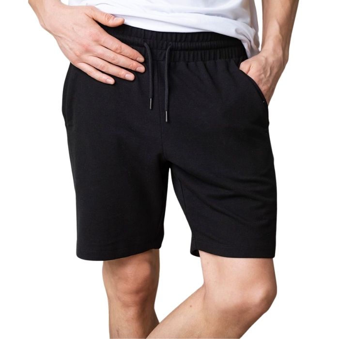 male model wearing black aspen shorts front view on white background