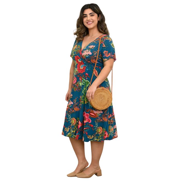 woman wearing teal fantasy print aurora dress side view set on a white background