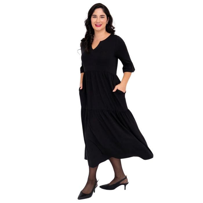 female model wearing black bernadette dress side view on white background