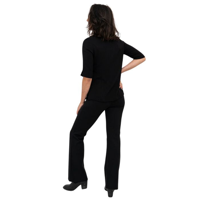 female model wearing black daya pants and black lorrine blouse back view on white background
