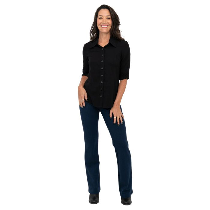 female model wearing indigo blue daya pants and black lorrine blouse front view on white background