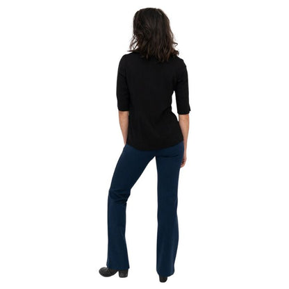 female model wearing indigo blue daya pants and black lorrine blouse back view on white background