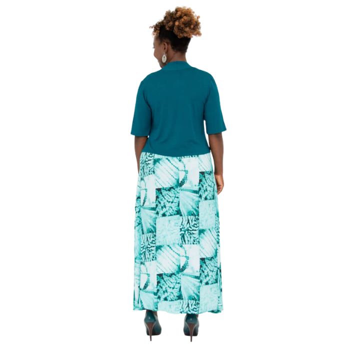 female model wearing teal green doda jacket and print maxi dress back view on white background