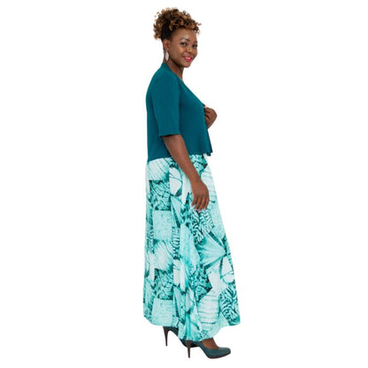 female model wearing teal green doda jacket and print maxi dress side view on white background