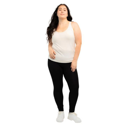 female model wearing cream white effortless bra in tank top and black suri leggings front view on white background