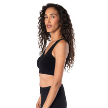 top of female model wearing black  essential bralette side view on white background