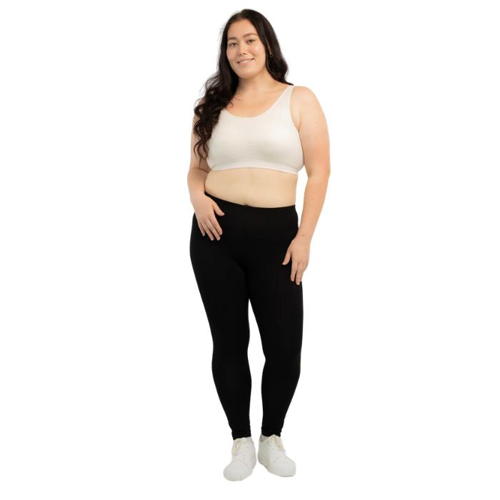 female model wearing cream white essential bralette and black suri leggings front view on white background