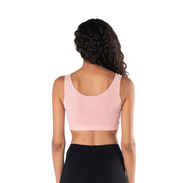 female model wearing pink essential bralette back view on white background