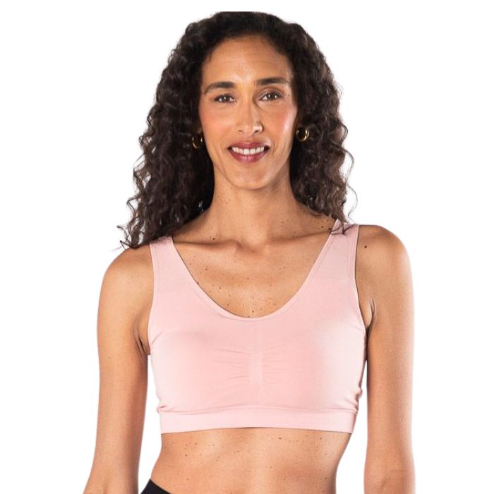 female model wearing pink essential bralette front view on white background