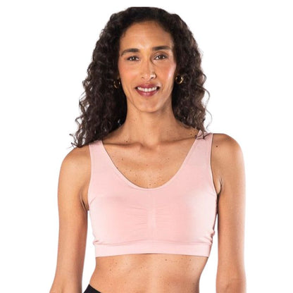 female model wearing pink essential bralette front view on white background