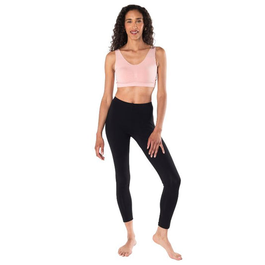 female model wearing pink essential bralette and black suri leggings front view on white background