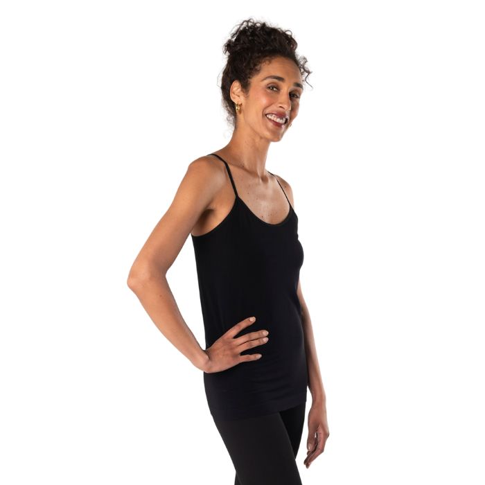 top of female model wearing black essential cami tank top side view on white background