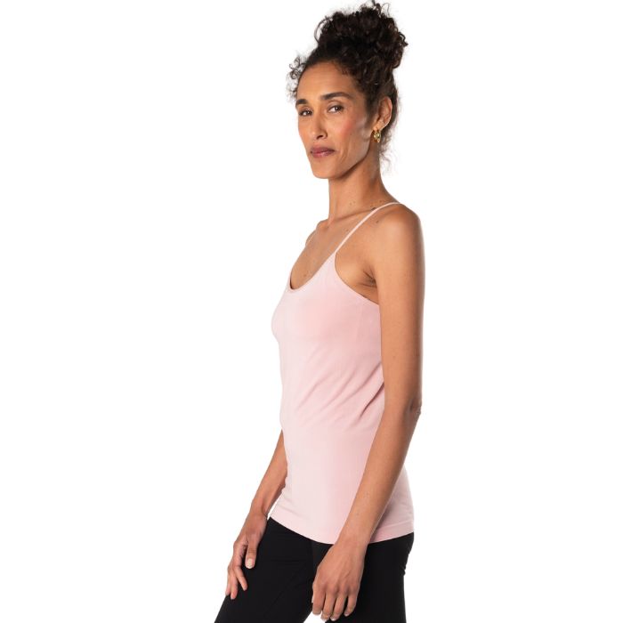 top of female model wearing pink essential cami tank top side view on white background