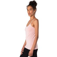 top of female model wearing pink essential cami tank top side view on white background