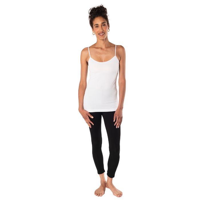 top of female model wearing white essential cami tank top and black suri leggings front view on white background