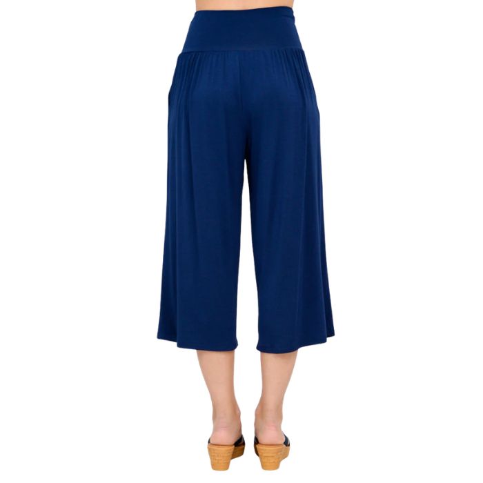 female model wearing indigo blue gaylene capri pants back view on white background