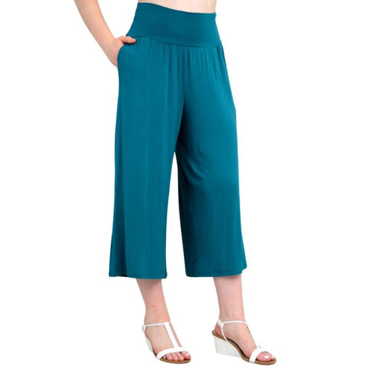 female model wearing teal green gaylene capri pants side view on white background