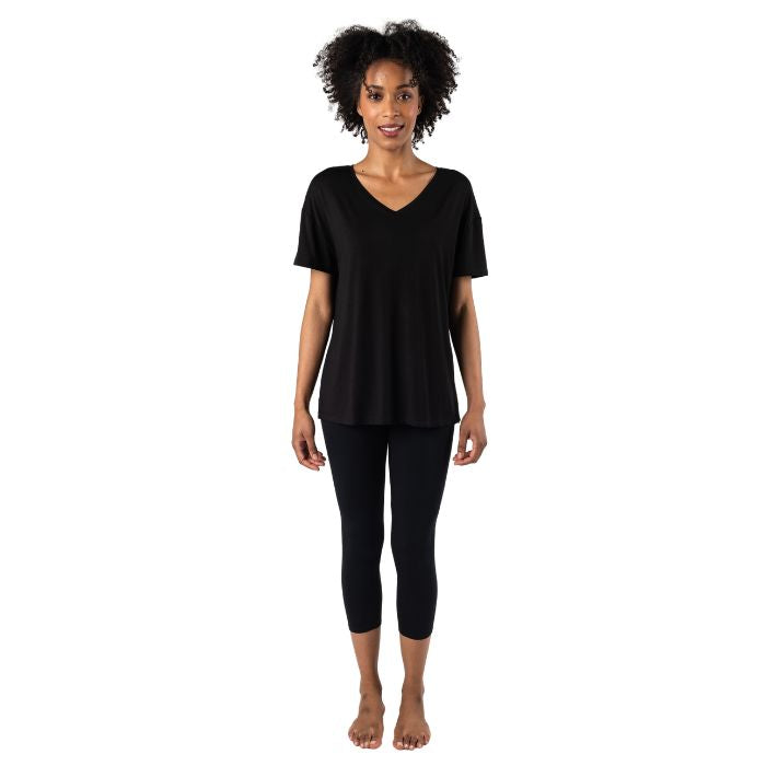 female model wearing black harper tee and black suri capri leggings front view on white background