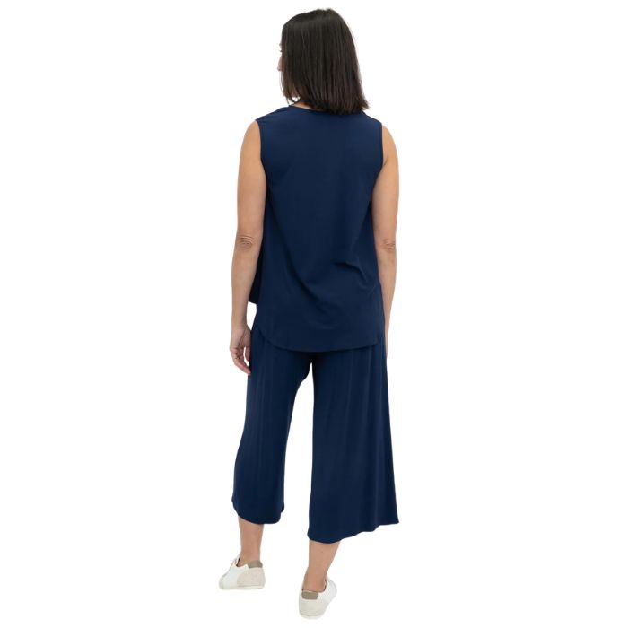 female model wearing indigo blue jackie tank top and indigo blue gaylene cropped pants back view on white backround