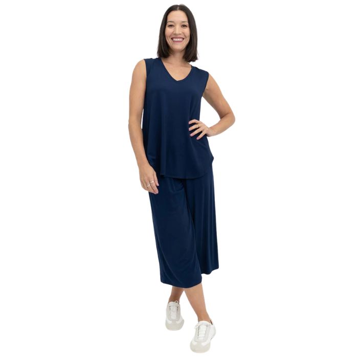female model wearing indigo blue jackie tank top and indigo blue gaylene cropped pants front view on white backround