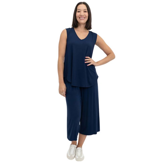 female model wearing indigo blue jackie tank top and indigo blue gaylene cropped pants front view on white backround