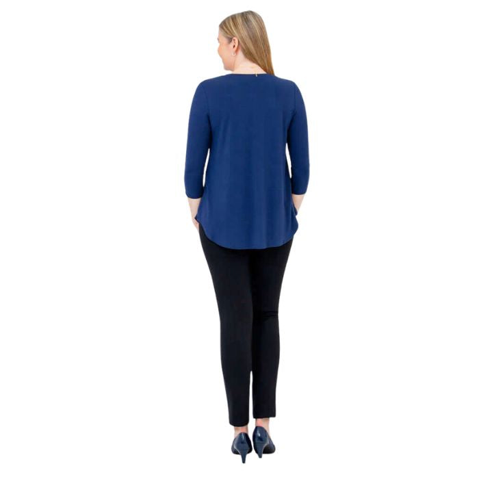 female model wearing indigo blue jackie top and black nadia pants back view on white backround