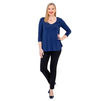 female model wearing indigo blue jackie top and black nadia pants front view on white backround