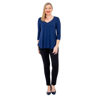 female model wearing indigo blue jackie top and black nadia pants front view on white backround