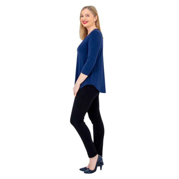 female model wearing indigo blue jackie top and black nadia pants side view on white backround