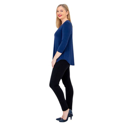 female model wearing indigo blue jackie top and black nadia pants side view on white backround