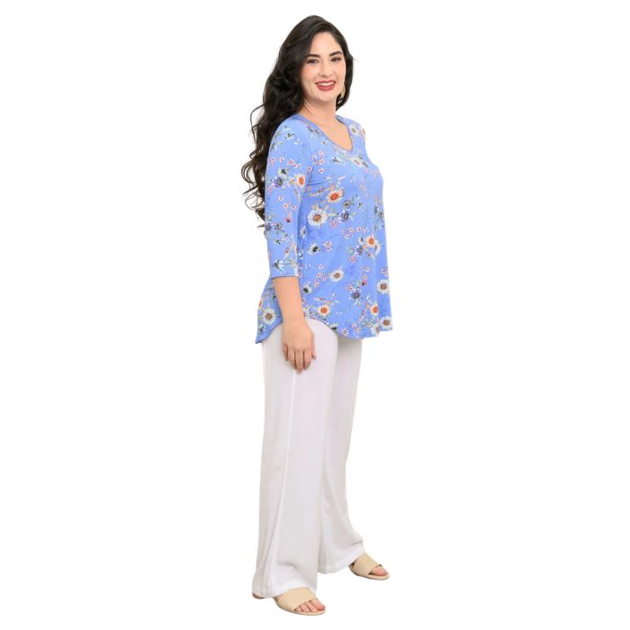 female model wearing peri daisy print jackie top and white landon pants side view on white backround