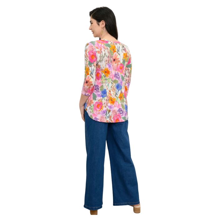 female model wearing pink bouquet print jackie top and denim blue jeans back view on white backround