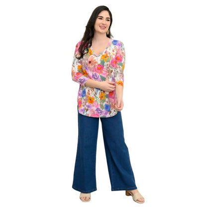female model wearing pink bouquet print jackie top and denim blue jeans front view on white backround