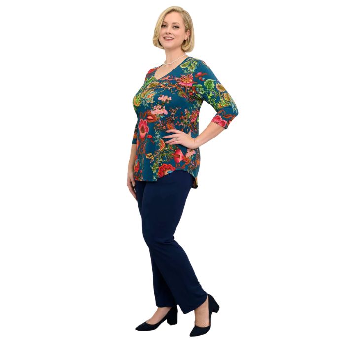 female model wearing teal fantasy print jackie top and indigo blue daya pants front view on white backround