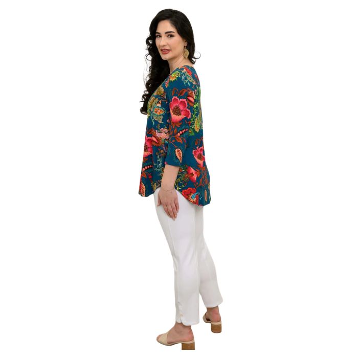 female model wearing teal fantasy print jackie top and white nadia cropped pants side view on white backround