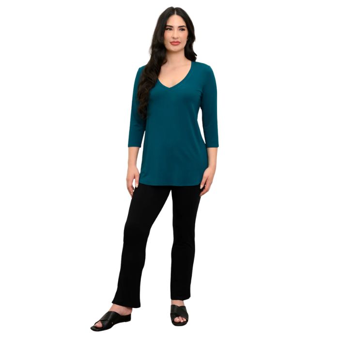 female model wearing teal green jackie top and black bella pants front view on white backround