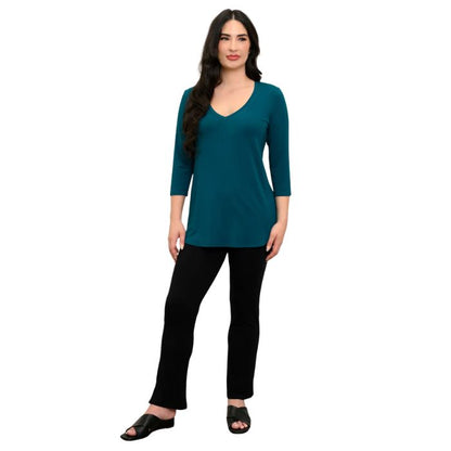 female model wearing teal green jackie top and black bella pants front view on white backround