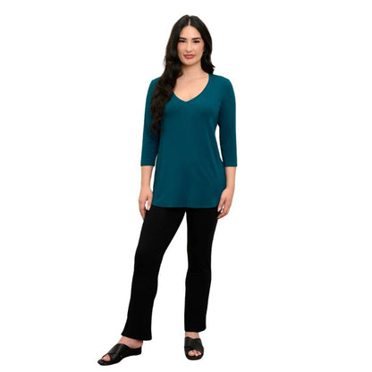 female model wearing teal green jackie top and black bella pants front view on white backround