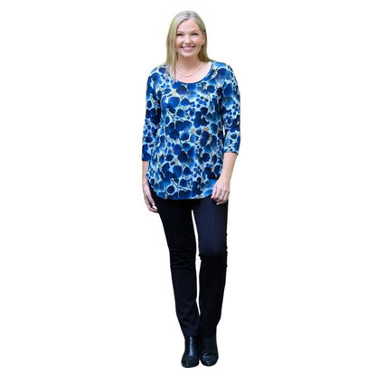 a women wearing blue wind print jazz  top and indigo blue nadia pants front view on white background