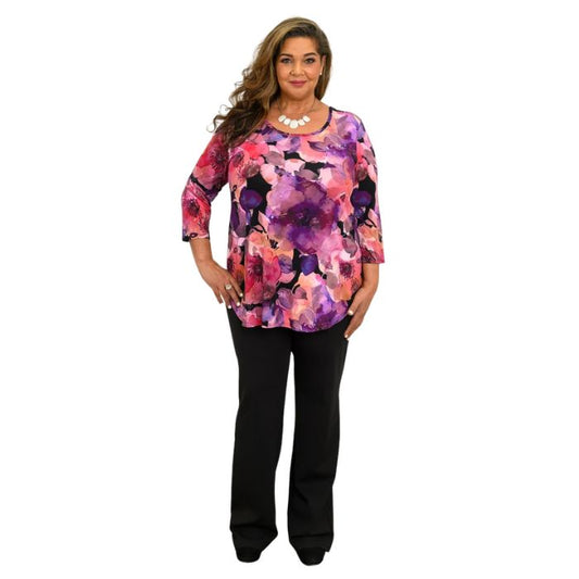 a women wearing royale garden print jazz top and black daya pants front view on white background
